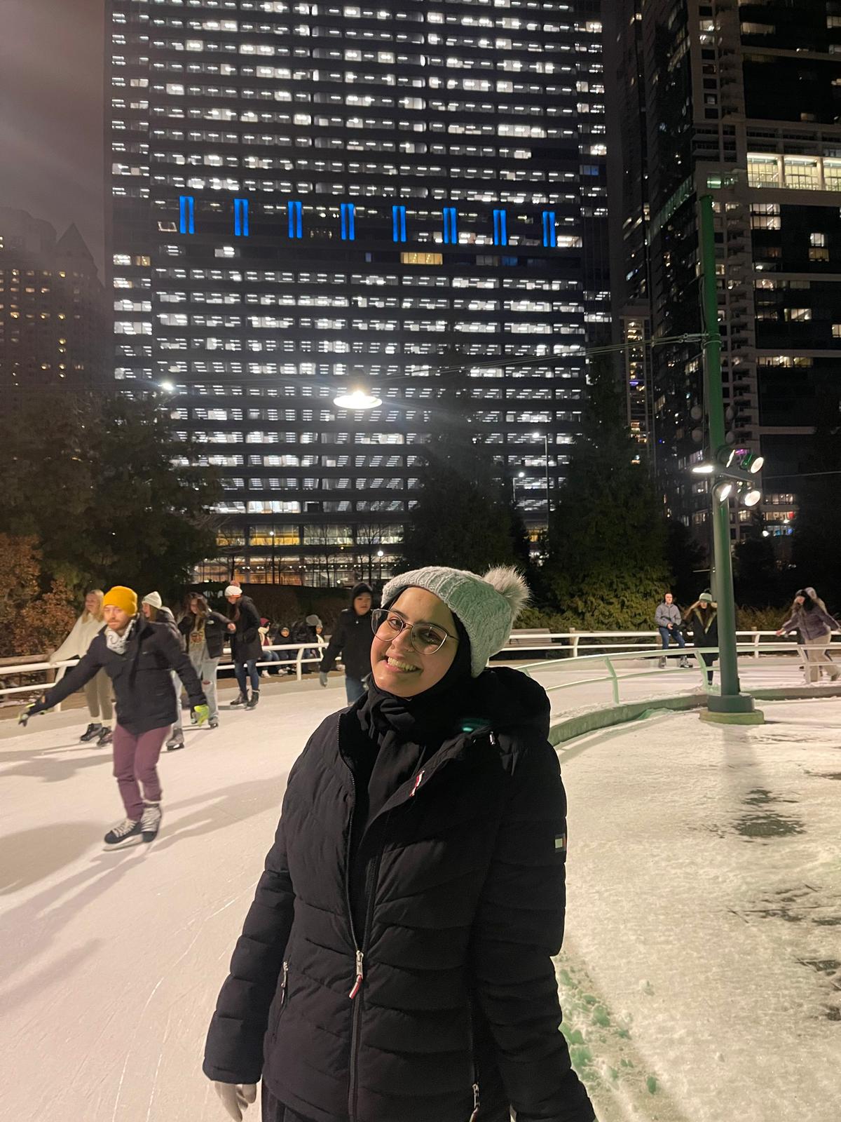 A woman poses in an urban ice skating rink at night